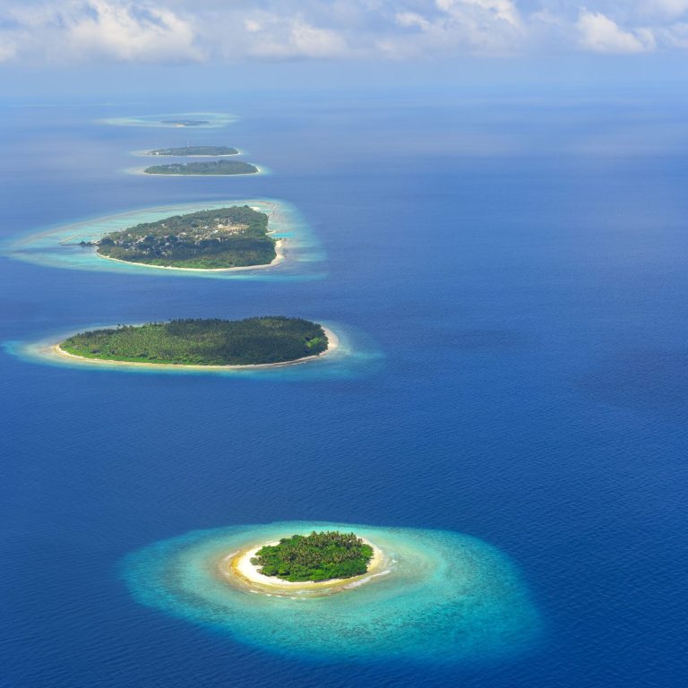 Stunning aerial shot of a chain of tropical islands in the Maldives surrounded by turquoise waters.